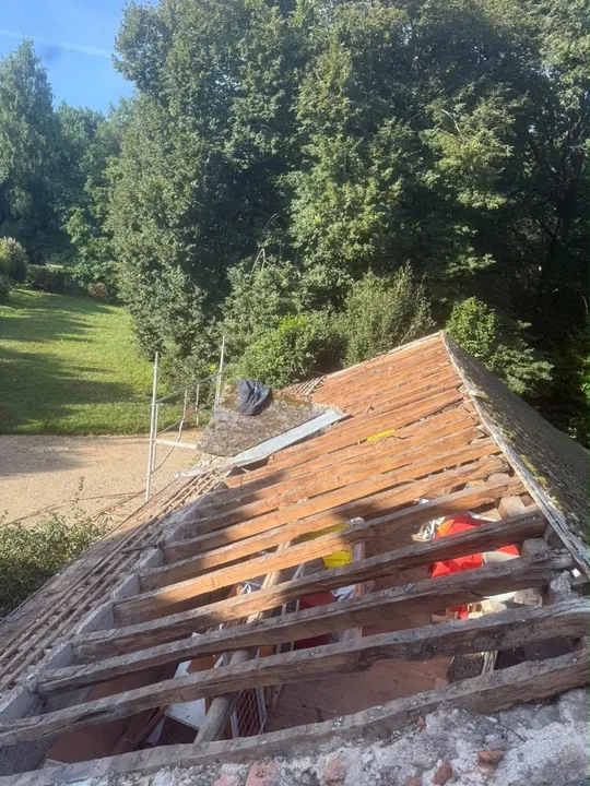 Pièces de bois apparentes sur une toiture après dépose de la couverture.